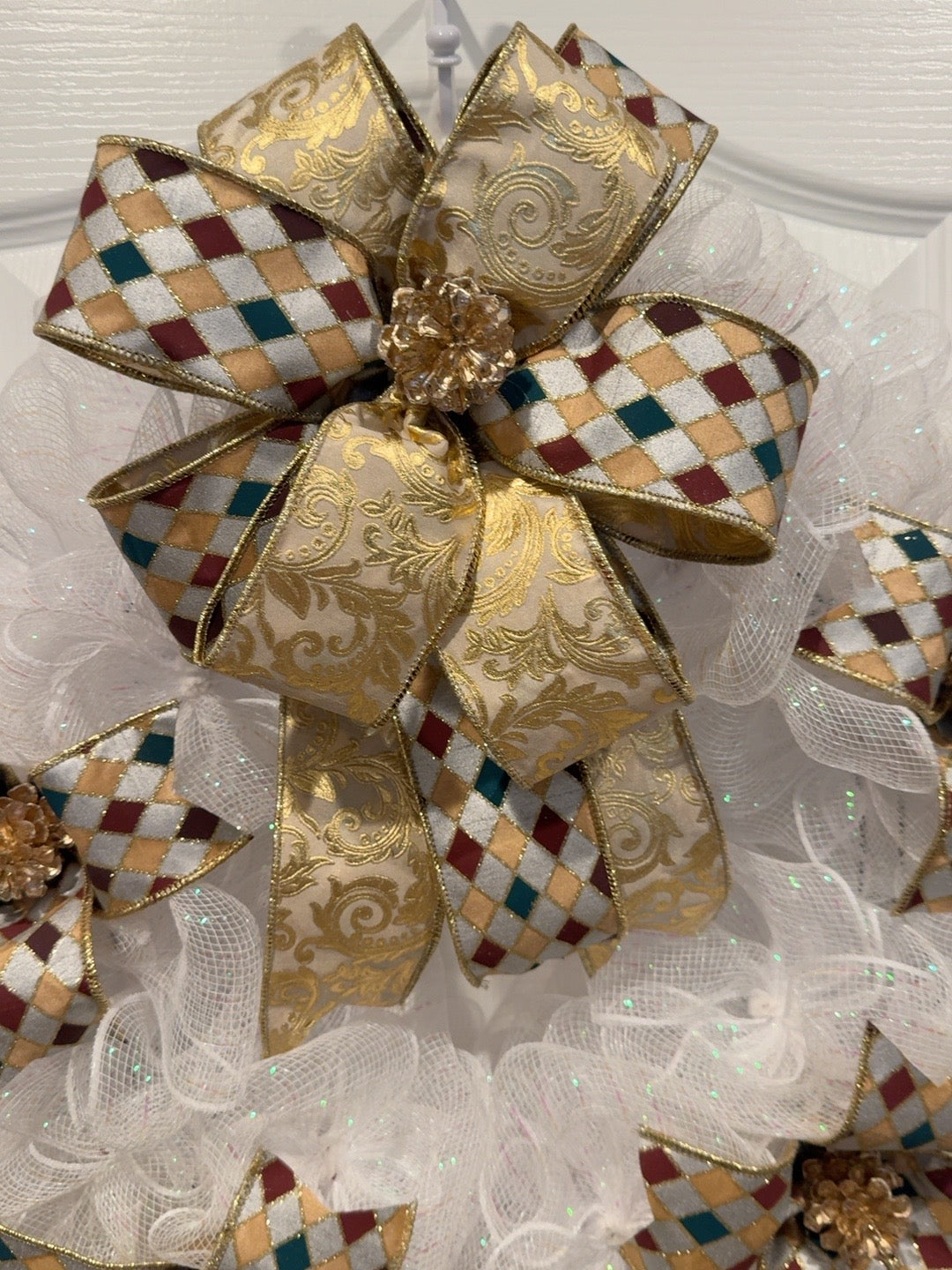 Close-up of gold damask bow and gold pinecone on handmade Christmas wreath