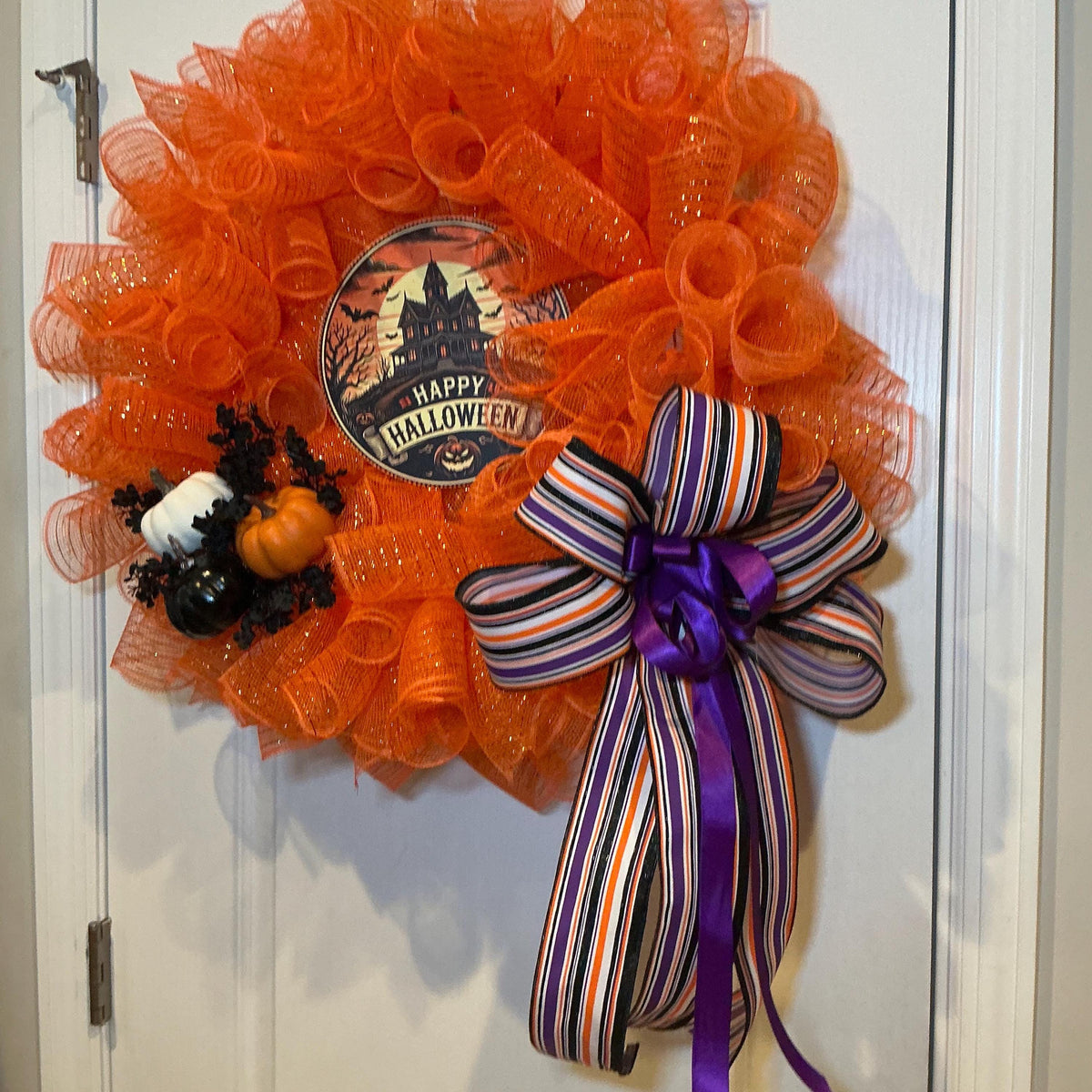 Haunted House Halloween Wreath, 18 Inch Orange Mesh with Black White Pumpkins and Purple Bow — actual product photo