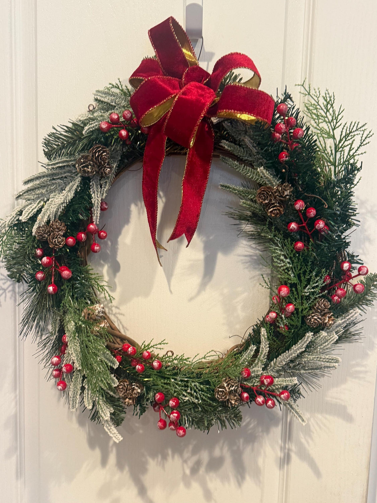Flocked Christmas Wreath, Red Berries, Pinecones, Red Velvet Bow, Grapevine Base — actual product photo