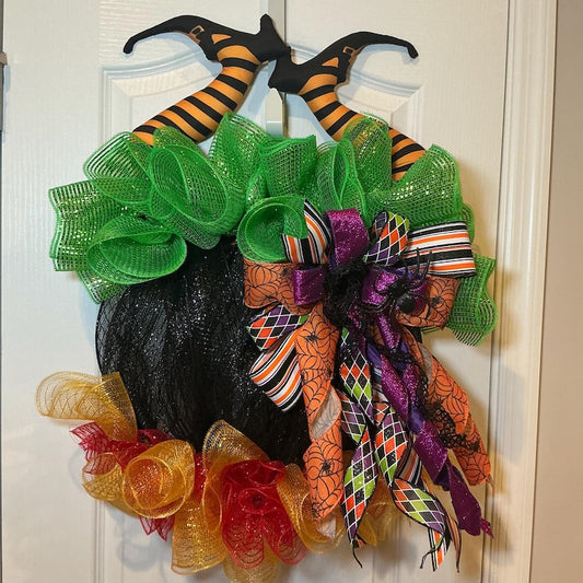 Actual front photograph of Halloween cauldron wreath with witch legs